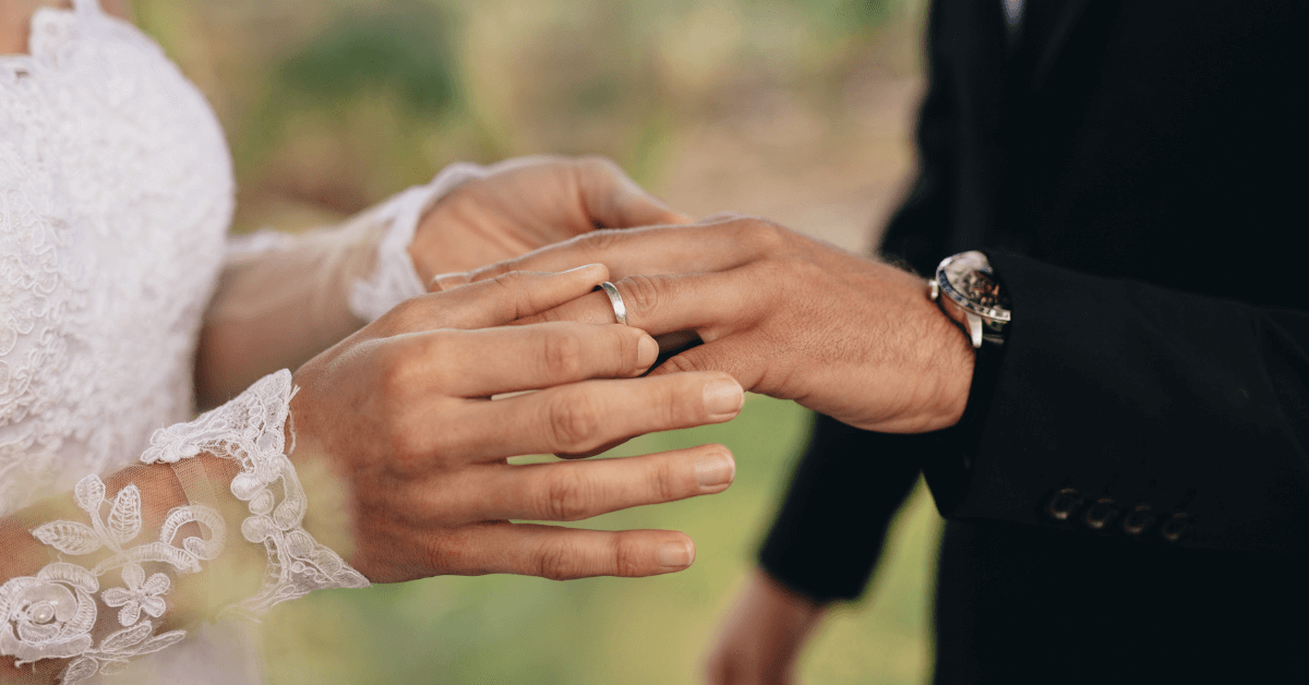 A newly wed couple looking at men's wedding band material