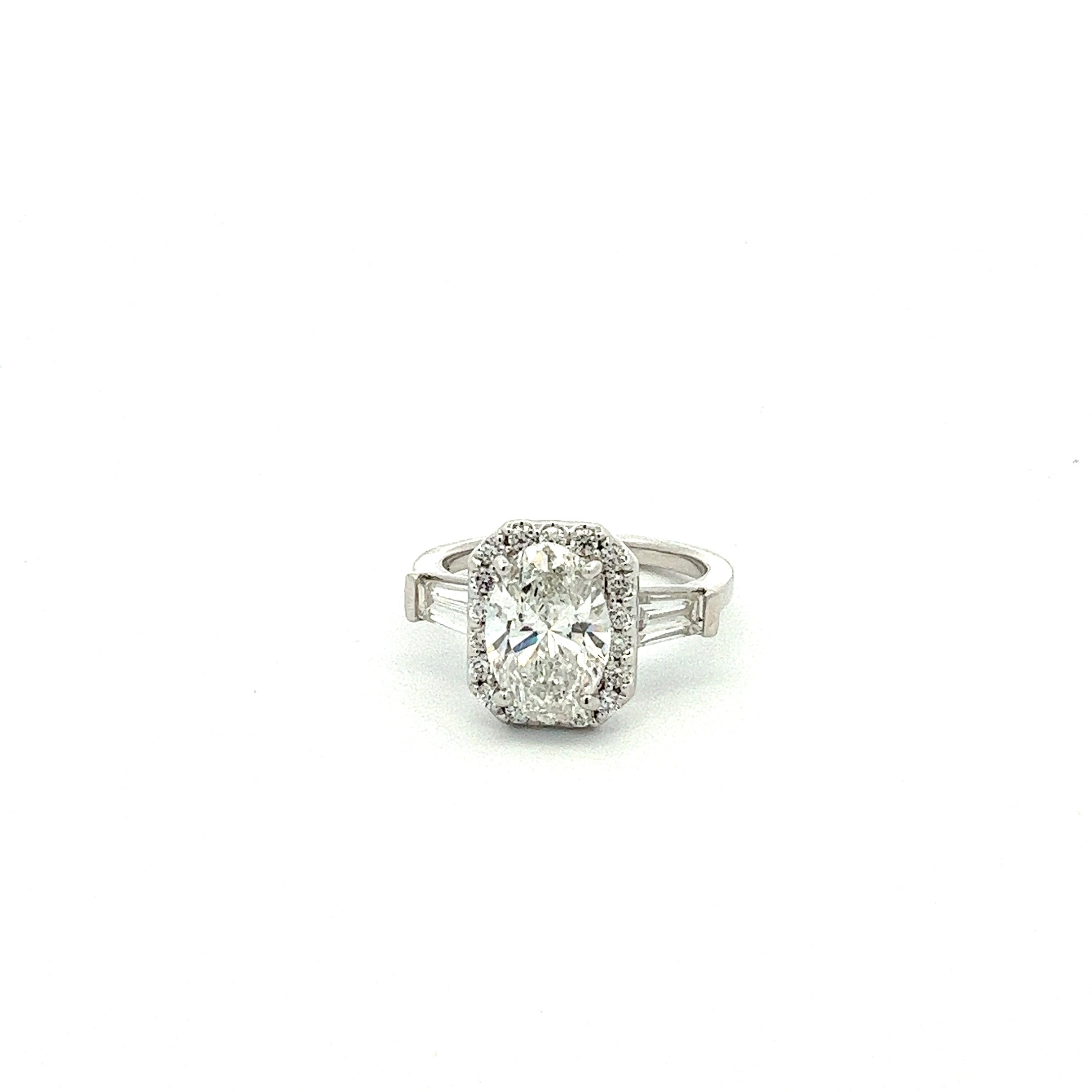 LG OVAL, BAGUETTE, & ROUND DIAMONDS 3.58CTW THREE STONE HALO CENTER RING