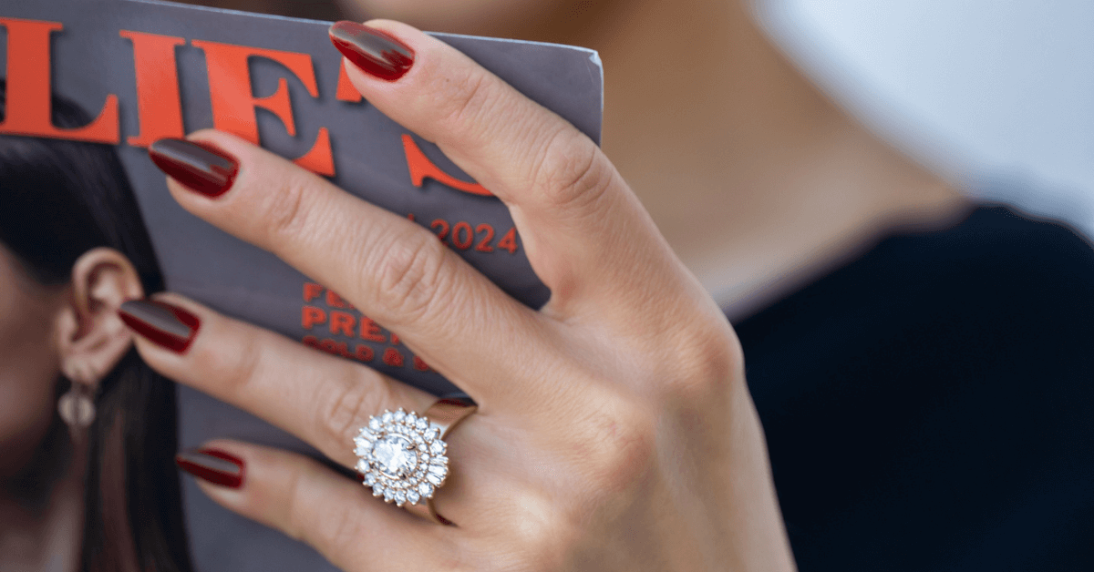 Artistic close up shot of a woman reading a magazine while wearing a brilliant diamond ring on her ring finger